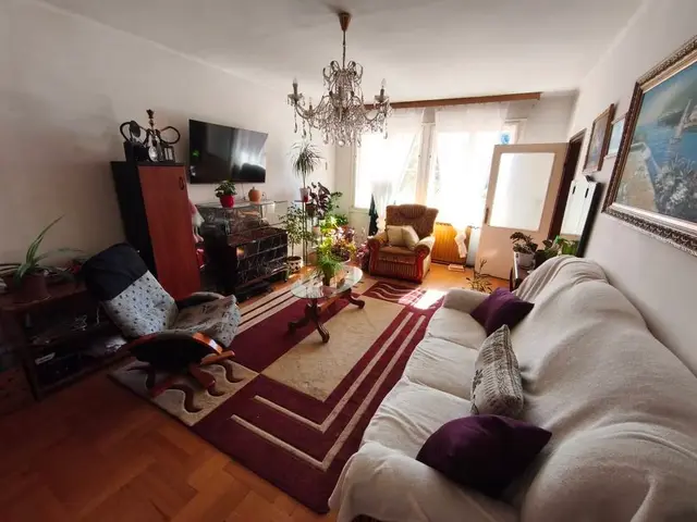 Nappali kanapéval, csillárral és utcára néző ablakokkal