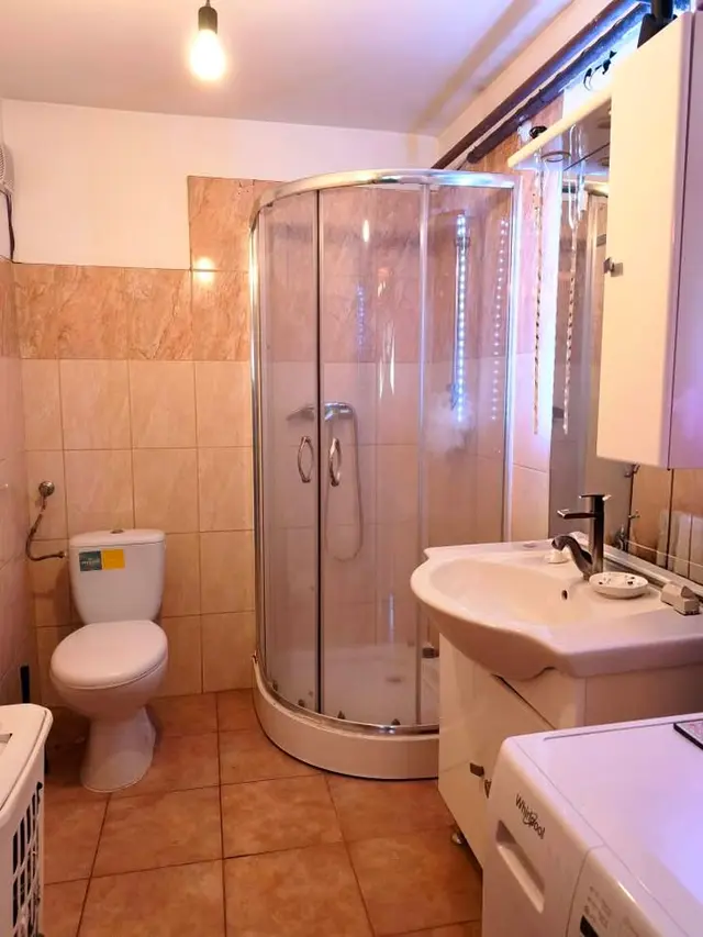 Fürdőszoba sarokzuhanyzóval, mosdóval és WC-vel